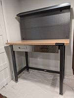 front view showing wood top, metal frame, pegboard backing and drawers