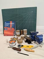 Full view of leatherworking supplies laid out on white surface against a wall, showing all items from seller's description
