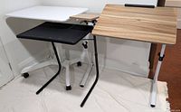 Photo showing all three desks side by side including the white sit/stand desk, black foldable tray desk, and wood laminate foldable desk.