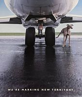 Close-up detail of the poster showing the landing gear of an airplane with a greyhound dog beside it and the phrase 'WE'RE MARKING NEW TERRITORY'