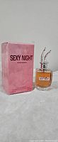 Photo showing the Sexy Night perfume bottle beside its original pink box with black text
