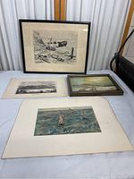 Full view of all four nautical prints, varying sizes, with two framed and two unframed prints on a light blue surface.