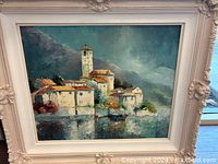 Full frontal view of oil painting in ornate white carved frame