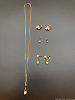 Overview of the gold filled pearl jewelry set showing the necklace and six earrings (three pairs).