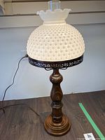 Full view of the vintage table lamp with hobnail milk glass shade and wooden turned base, showing height and cord.