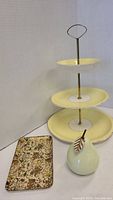Full shot of three-tier plate, small floral tray and ceramic pear figurine together
