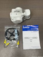 Photo showing the LED security light, installation accessories including mounting hardware and wire connectors, and the user manual.