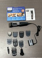 Philips Series 3000 All-in-One Trimmer and all included attachments, power adapter, cleaning brush and package.