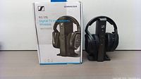 Front view of Sennheiser RS 175 box alongside headphone set on transmitter base.