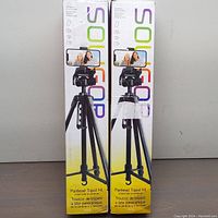Two original product boxes side by side, showing Soligor branding and tripod image with smartphone mounted.