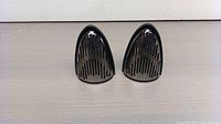 Pair of individual black TWS Bluetooth speakers upright, showing vent slat design and magnetic edges