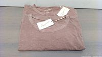 Two folded mauve Universal Thread 1X T-shirts with tags visible, displayed on flat surface.