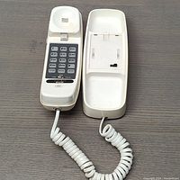 Full view of the opened Bell Trimline telephone showing handset and base with coiled cord.