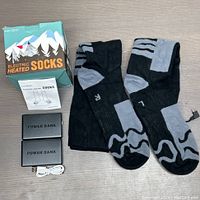 Full lot overview including the pair of XL electric heated socks, two power banks, USB charging cable, instruction manual, and box.