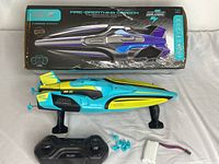 Boxed 4DRC Fire Breathing Dragon RC boat with remote controller, spare propellers, and battery pack displayed.