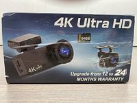 Box front showing 4K Ultra HD branding, image of front and rear camera, and 64GB memory card icon. Warranty upgraded to 24 months.