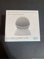 Front view of sealed Mission Battery Base packaging showing product image and key features including up to 5 hours portable playtime.