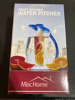 Box front of the fruit infuser water pitcher showing pitcher filled with water and citrus slices, with blue lid and handle, MiscHome brand name visible.