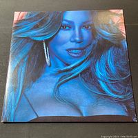 Front cover of Mariah Carey Caution vinyl album showing close-up portrait of Mariah Carey in blue light.