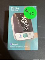 Front box image showing the Meraw Cedar blood pressure monitor with Bluetooth and LCD display.