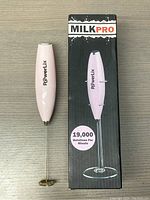 Pink handheld PowerLix electric milk frother with stainless steel whisk alongside its black box showing the brand and 19,000 rotations per minute.
