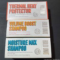 Three boxed Bold Uniq hair care products stacked showing Thermal Heat Protector, Volume Boost Shampoo, and Moisture Max Shampoo.