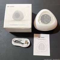 Heyjar HE-X002 washing machine with box, USB cable, and user manual displayed on a table.