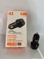 Photo of the IQ Rapid Charge In-Car Charger with its original retail box. The box displays charger image, branding, and details of USB Power Delivery 20W and USB-C port.