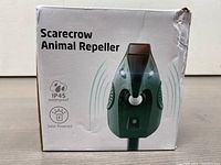Front of packaging showing the Solar Powered Scarecrow Animal Repeller and waterproof and solar powered features
