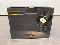 Front of retail packaging showing image of the black and gold Wireless Magnetic Wall Light with '16 RGB colors' and 'warm, natural, cool light' options noted.