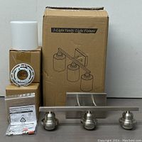 3-Light Vanity Light Fixture components displayed together, including light bar with 3 lamp holders, frosted glass shade, mounting bracket, user manual, and electrical installation hardware.