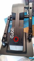 Side view of the Cubii elliptical base showing the brand name and red resistance dial on the side.