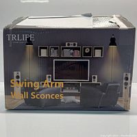 Box packaging for Trlife Swing Arm Wall Sconces showing photograph of two sconces on a living room wall and printed branding.