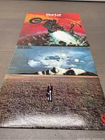 Top view of two vinyl record album covers laid flat: Meat Loaf Bat Out of Hell on top and John Lennon Mind Games below.