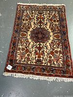 Full view of the handmade Bijar rug laid flat on the floor showing floral and medallion pattern with fringe edges.