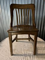Front view of oak banker chair showing seat and slatted back design