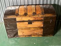 Front and side angle view of the antique barrel top trunk showing wood slats, metal bands, and side handles.