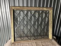 Full view of antique leaded glass window showing wooden frame and diamond lattice glass pattern.