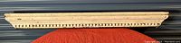 Front view of antique wooden mantle with dental molding in off-white paint showing length and detail.