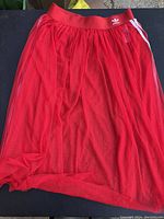 Full view of red mesh skirt with elastic waistband and Adidas trefoil logo.
