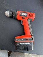Side profile of a Black & Decker cordless battery drill showing model and volt info.