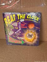 Front of Beat the Clock 1998 trivia game box featuring colorful graphics, stopwatch image, and game details.
