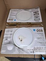 Photo showing two LED downlights in their original packaging inside a box.
