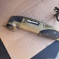 Side view of the SnoopSeries oscillating multi-tool showing the handle, ventilation slots, and attached cutting blade.