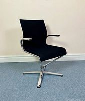 Full view of black Dauphin office chair angled showing seat, backrest, chrome frame, and base.