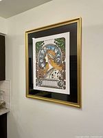 Framed lithograph hung on wall, viewed slightly from left angle