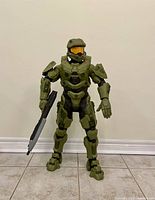 Front view of Master Chief figure standing upright holding a rifle in right hand.