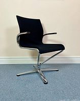 Front angle of the black fabric Dauphin swivel armchair with chrome frame showing ribbed backrest and four-star base.