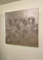 Front view of modern textured abstract acrylic painting featuring floral motif with radiating lines in neutral tones on square canvas