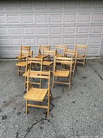 Ten chairs arranged outdoors in front of garage door